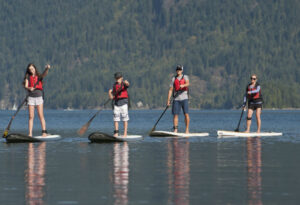 Family stand up paddleboarding in deep cove
