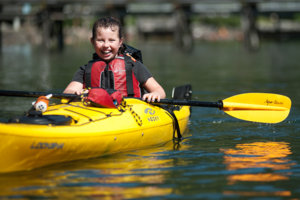 Child in Kayak Smiling during Pod Camp