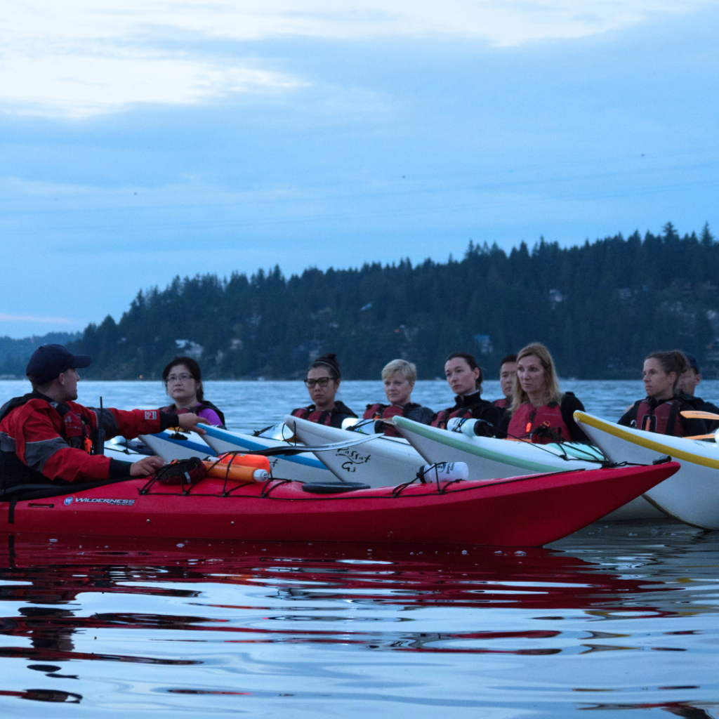 Group of kayakers with an instructor floating on the ocean